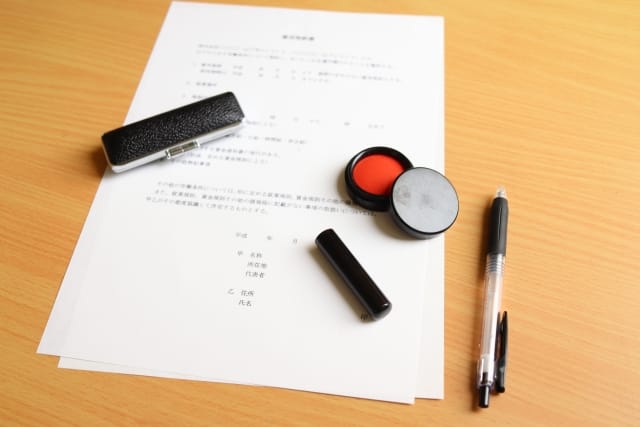 書類には日付や署名欄が印刷されており、契約の締結場面を想起させる