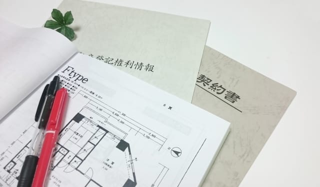 不動産の契約書や権利情報の書類が机の上に並べられている