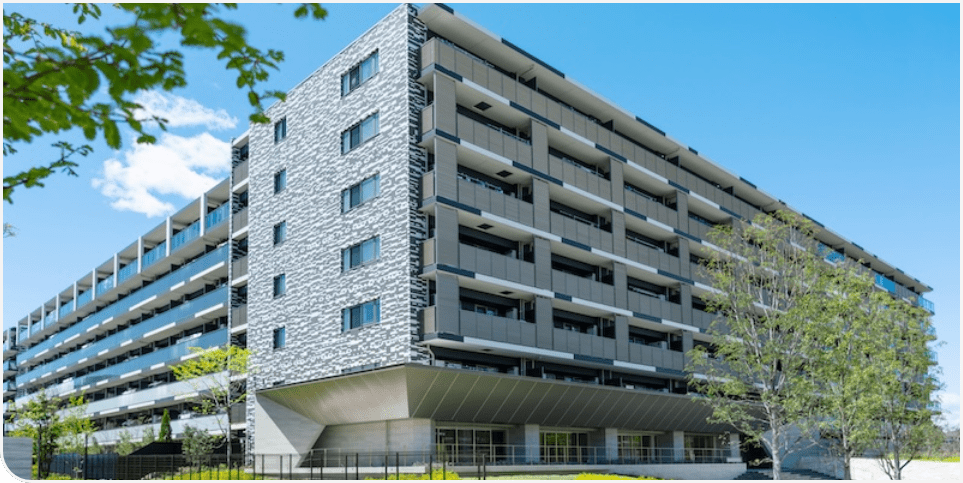 近代的なデザインの中高層マンションで、外壁はグレー系のタイルが施されている